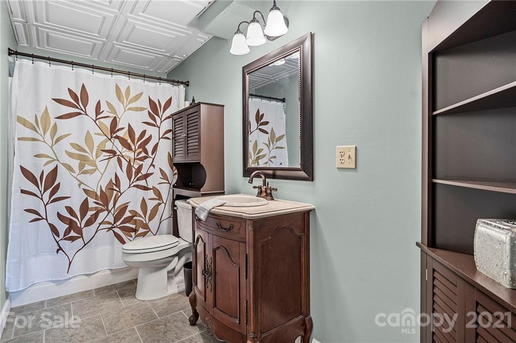 1004 Lickstone Road Waynesville, NC 28786 - Photo 26 of 39 a bathroom with a sink a toilet and shower curtain