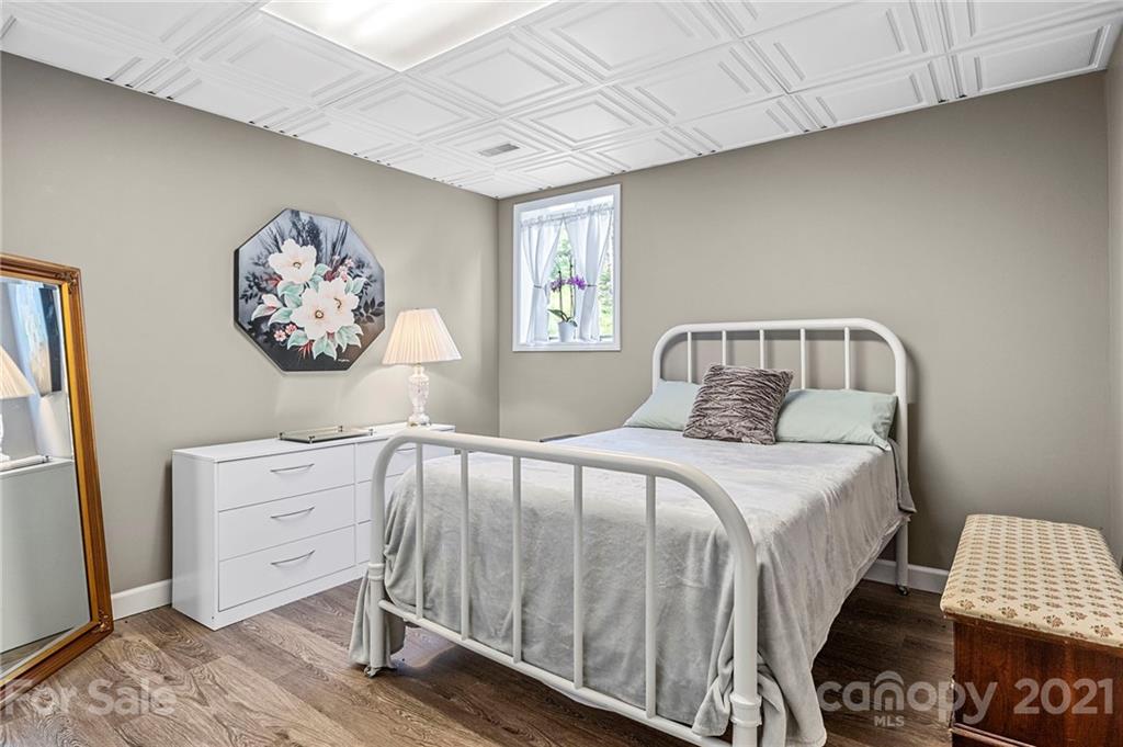 1004 Lickstone Road Waynesville, NC 28786 - Photo 28 of 39 a bedroom with a bed and a lamp on dresser