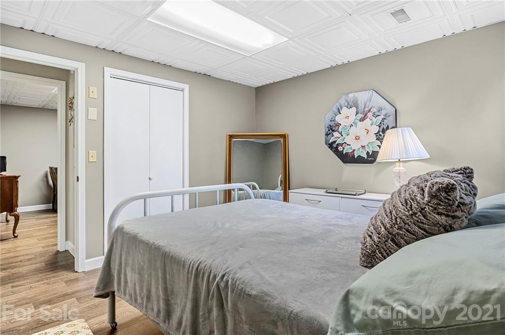 1004 Lickstone Road Waynesville, NC 28786 - Photo 29 of 39 a bedroom with a large bed and a chandelier