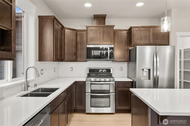 a kitchen with stainless steel appliances a refrigerator sink and stove