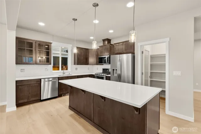 a open kitchen with stainless steel appliances granite countertop a refrigerator a sink a stove and oven