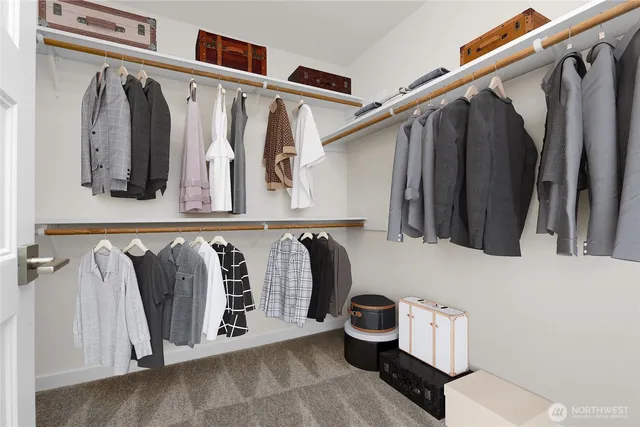 a view of walk in closet with clothes and shoes