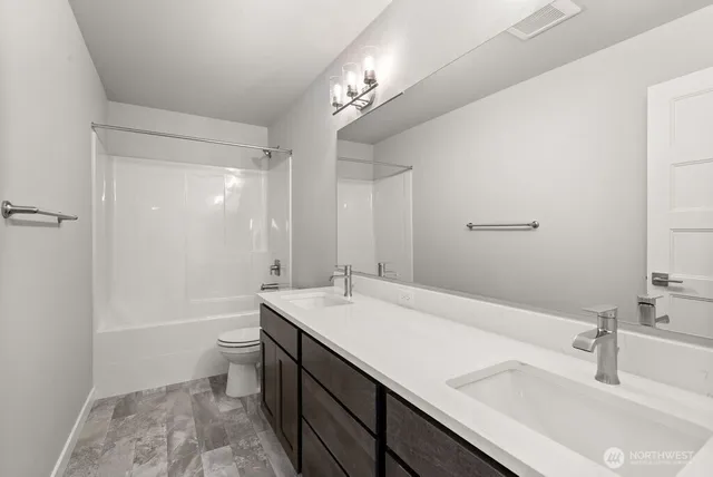 a bathroom with a sink a toilet a tub and shower