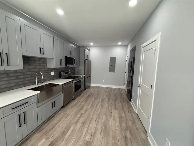 a kitchen with stainless steel appliances a refrigerator sink and microwave