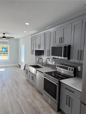 a kitchen with stainless steel appliances granite countertop a stove a sink and a microwave