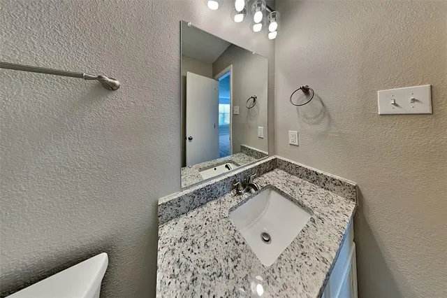 a bathroom with a sink mirror and vanity