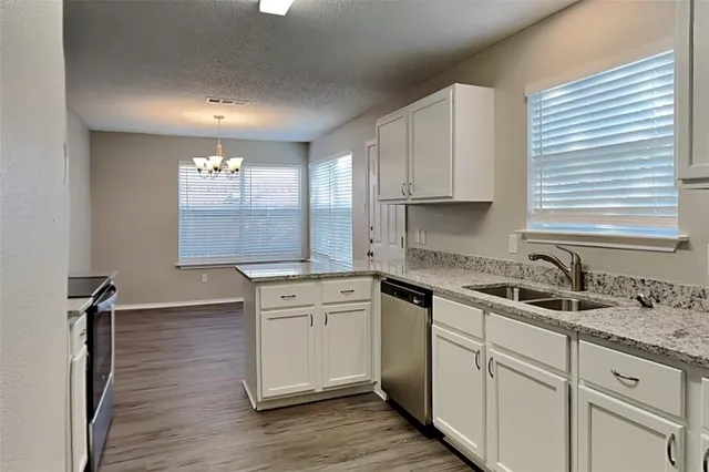a kitchen with cabinets appliances a sink and a window