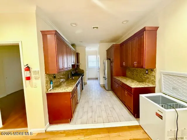 a large kitchen with stainless steel appliances granite countertop a stove a sink dishwasher and a refrigerator