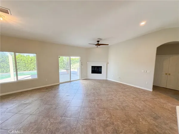 an empty room with windows and fireplace