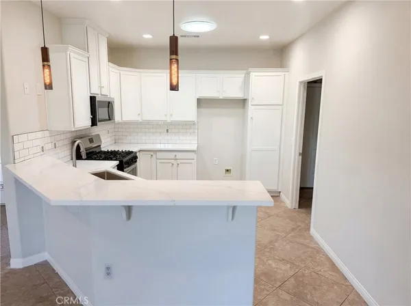 a kitchen with kitchen island a sink stainless steel appliances and cabinets