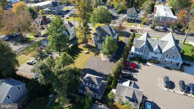 an aerial view of a house with a yard potted plants and large trees