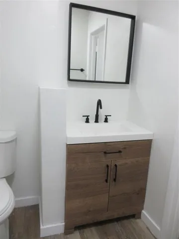 a bathroom with a sink a toilet and mirror