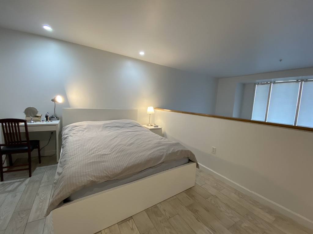 1 Earhart Street, Unit 702 Cambridge, MA 02141 - Photo 6 of 19 a bed sitting in a room next to a lamp