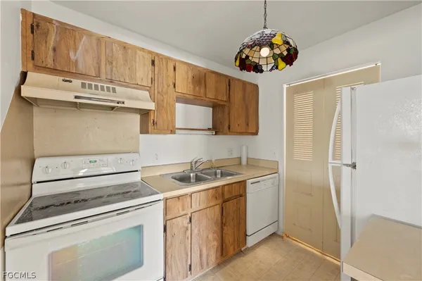 a kitchen with stainless steel appliances granite countertop a sink a stove and a refrigerator
