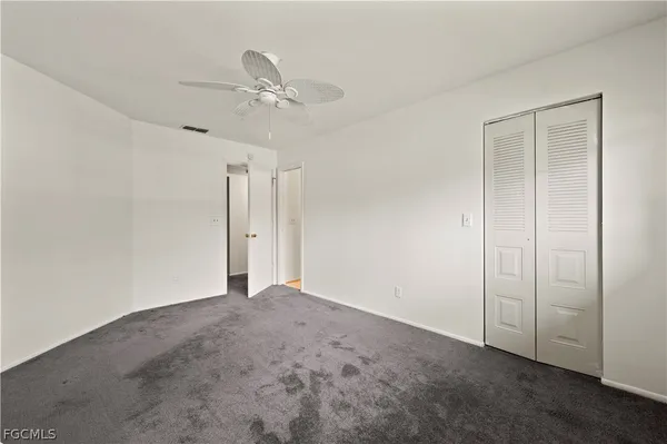 a view of an empty room and a ceiling fan