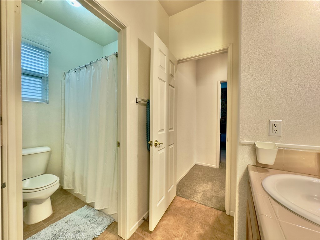 11265 Runyan Road Beaumont, CA 92223 - Photo 65 of 138 a bathroom with a granite countertop sink a toilet and shower