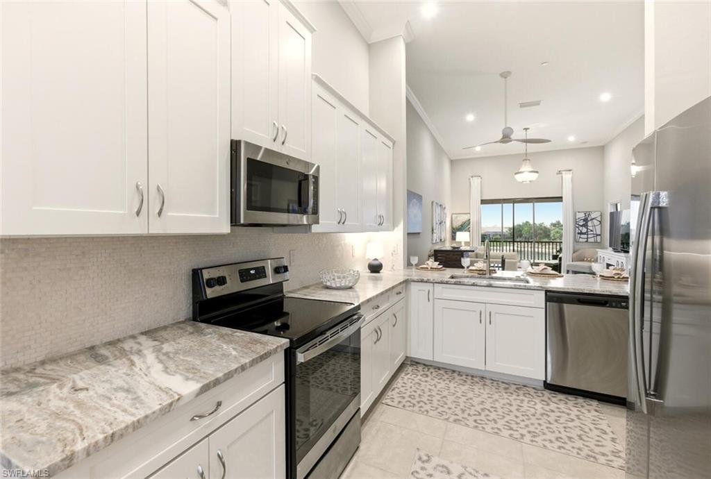 9365 Pocida Court, Unit 202 Naples, FL 34119 - Photo 5 of 40 a kitchen with a sink stove and microwave