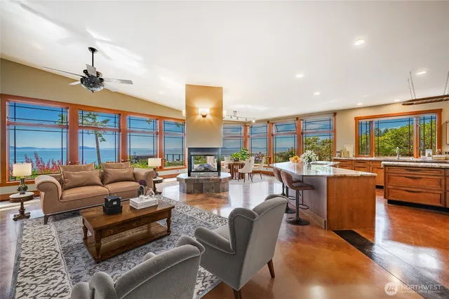 a living room with furniture kitchen view and a large window