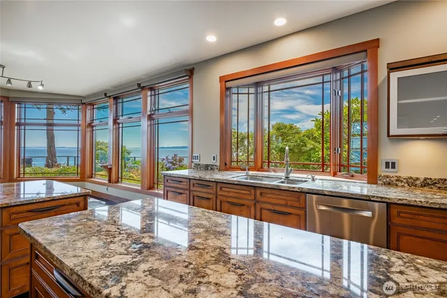 a large kitchen with kitchen island a large window in it