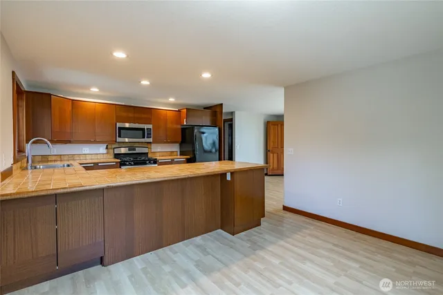 a view of kitchen with stainless steel appliances granite countertop refrigerator sink and stove