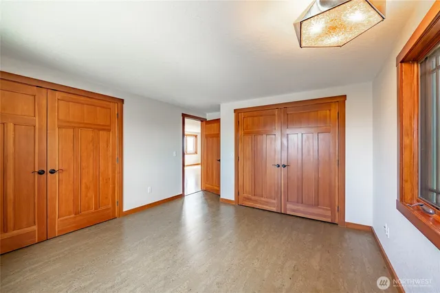 an empty room with window and closet area