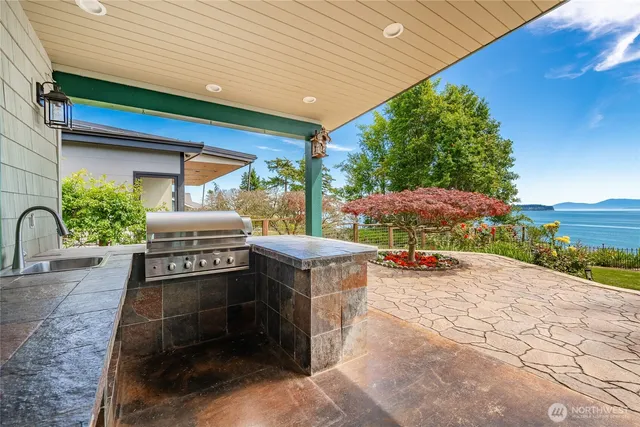 a view of a patio with a table and chairs under an umbrella