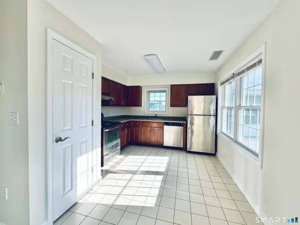 a kitchen with stainless steel appliances granite countertop a refrigerator and a stove top oven
