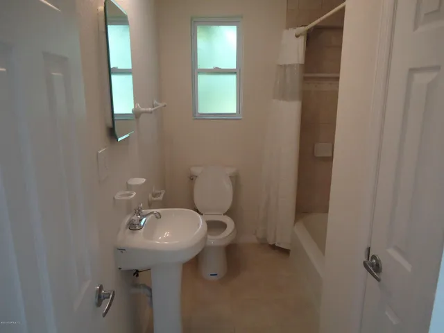 a bathroom with a sink toilet and a mirror