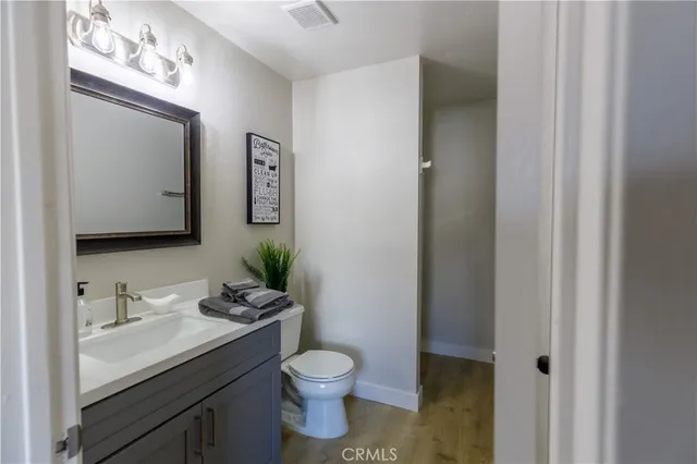 a bathroom with a granite countertop toilet sink and mirror