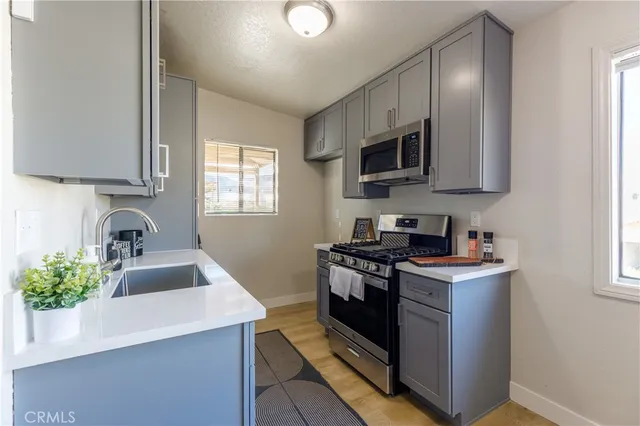 a kitchen with stainless steel appliances granite countertop a sink stove and microwave