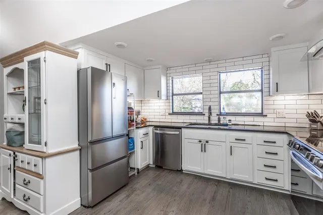 a kitchen with white cabinets and stainless steel appliances