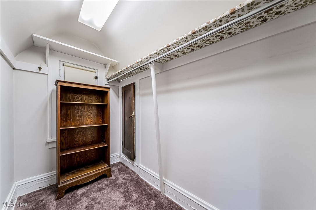 11703 Granger Road Cleveland, OH 44125 - Photo 40 of 41 Walk in closet featuring dark carpet and vaulted ceiling