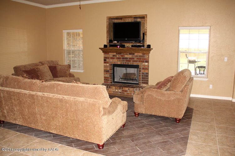 1041 Copper Ridge Bushland, TX 79124 - Photo 7 of 46 a living room with furniture a flat screen tv and a fireplace