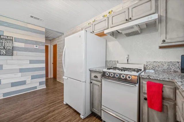 a kitchen with stainless steel appliances granite countertop a stove and a refrigerator