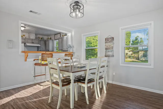 a view of a dining room with furniture a chandelier and wooden floor