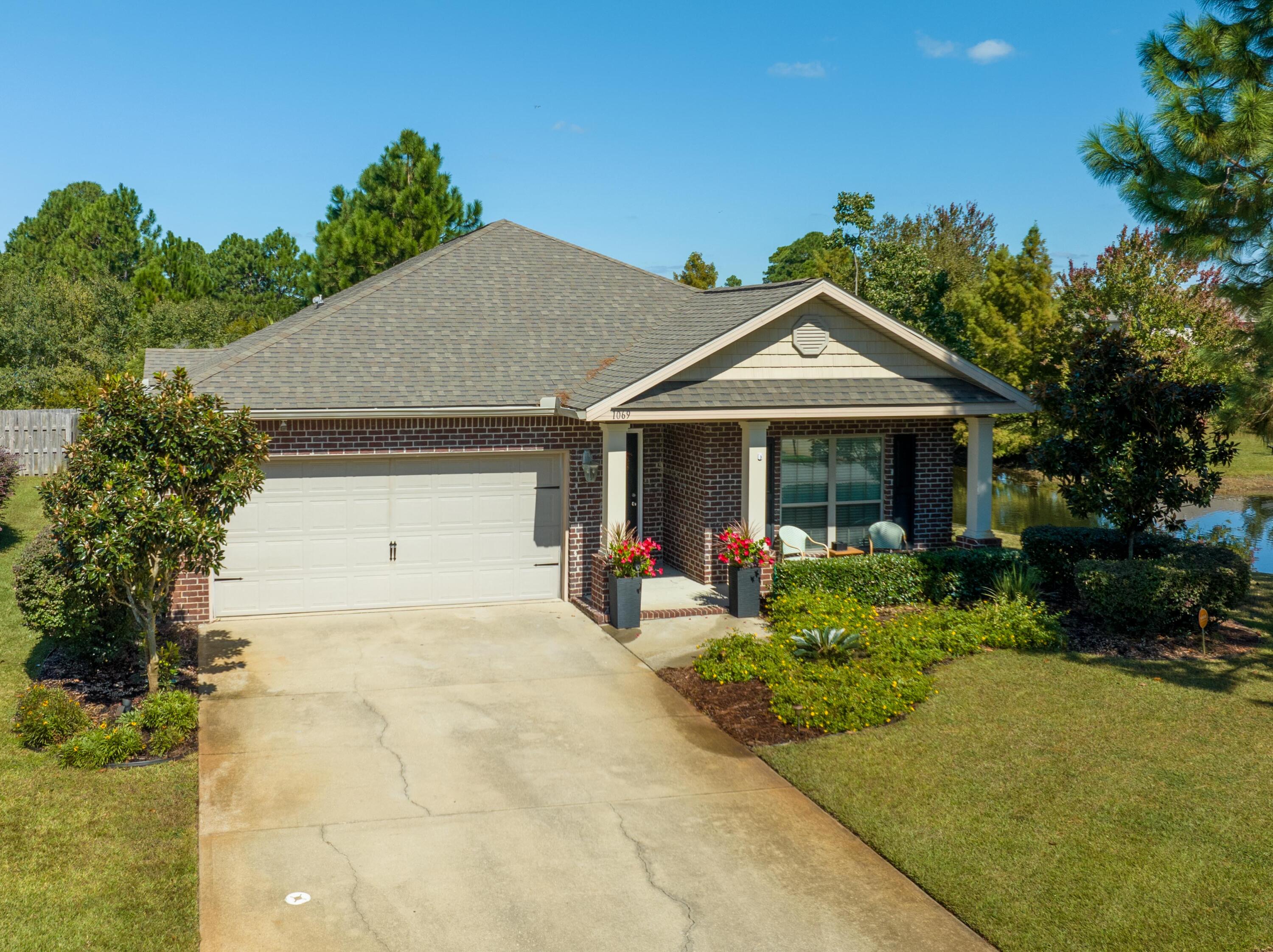 1069 Cocobolo Drive Santa Rosa Beach, FL 32459 - Photo 1 of 46 a front view of a house with garden