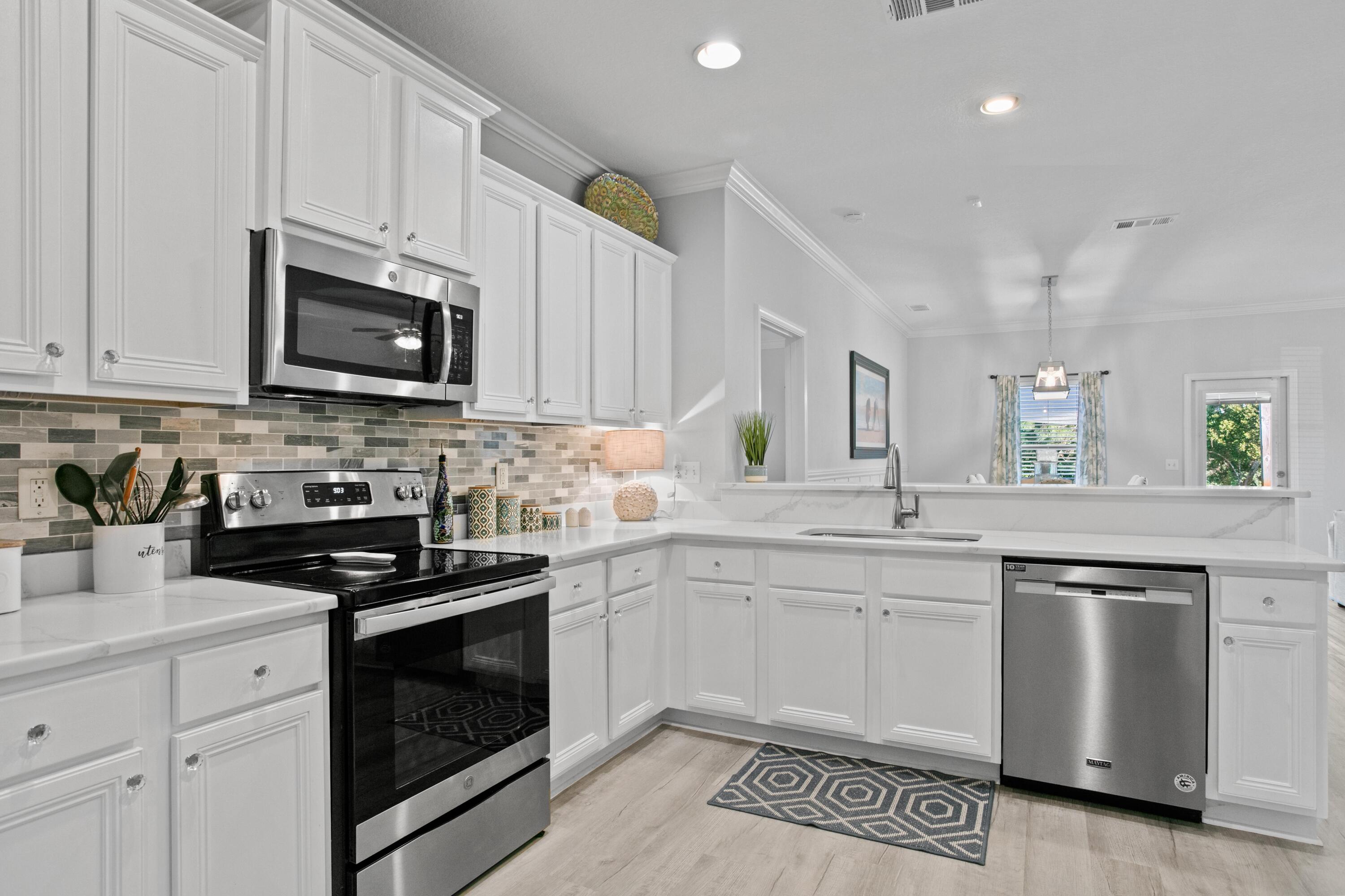 1069 Cocobolo Drive Santa Rosa Beach, FL 32459 - Photo 11 of 46 a kitchen with granite countertop cabinets stainless steel appliances and a sink