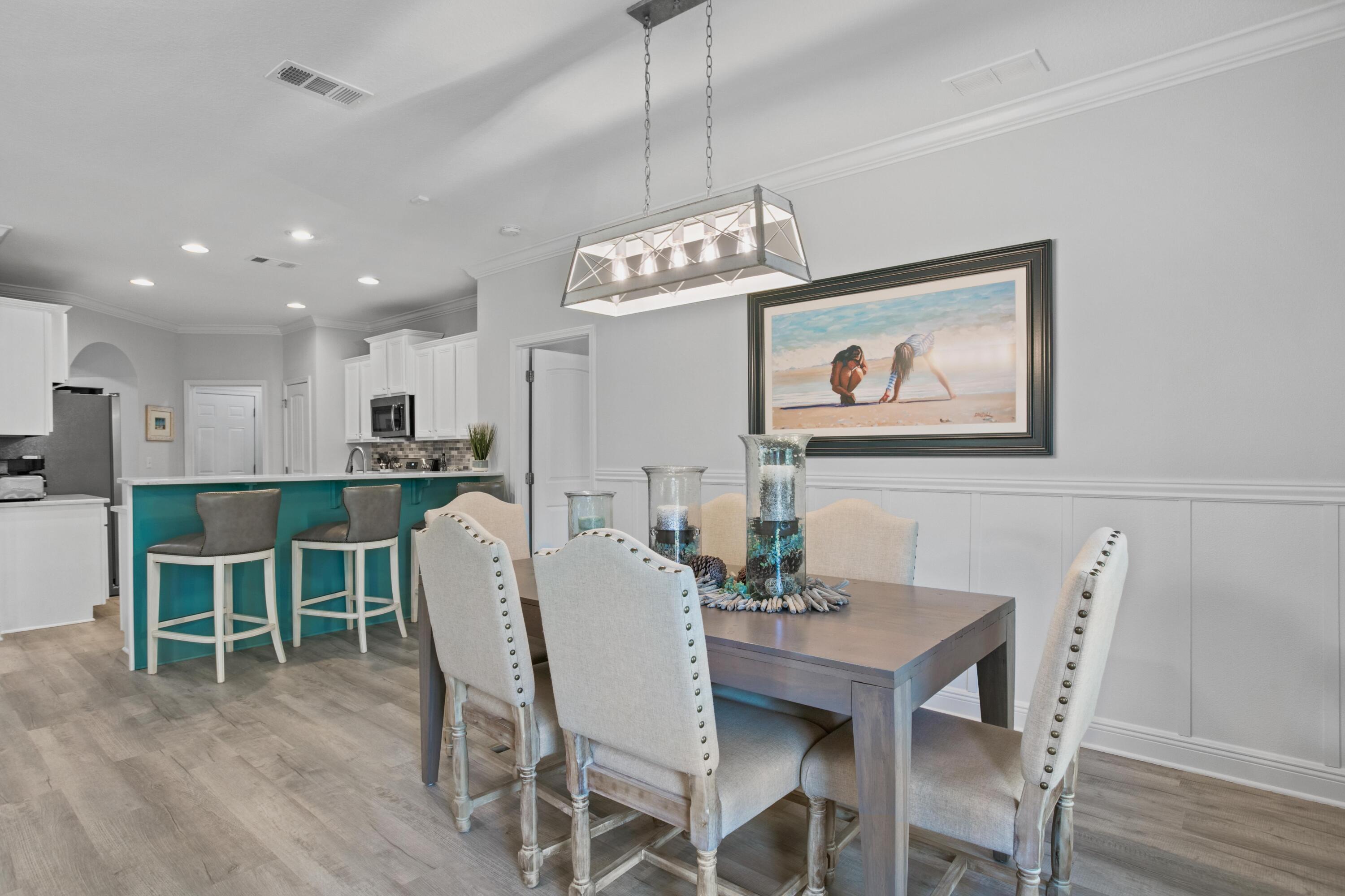 1069 Cocobolo Drive Santa Rosa Beach, FL 32459 - Photo 24 of 46 a view of a dining room with furniture wooden floor and a chandelier