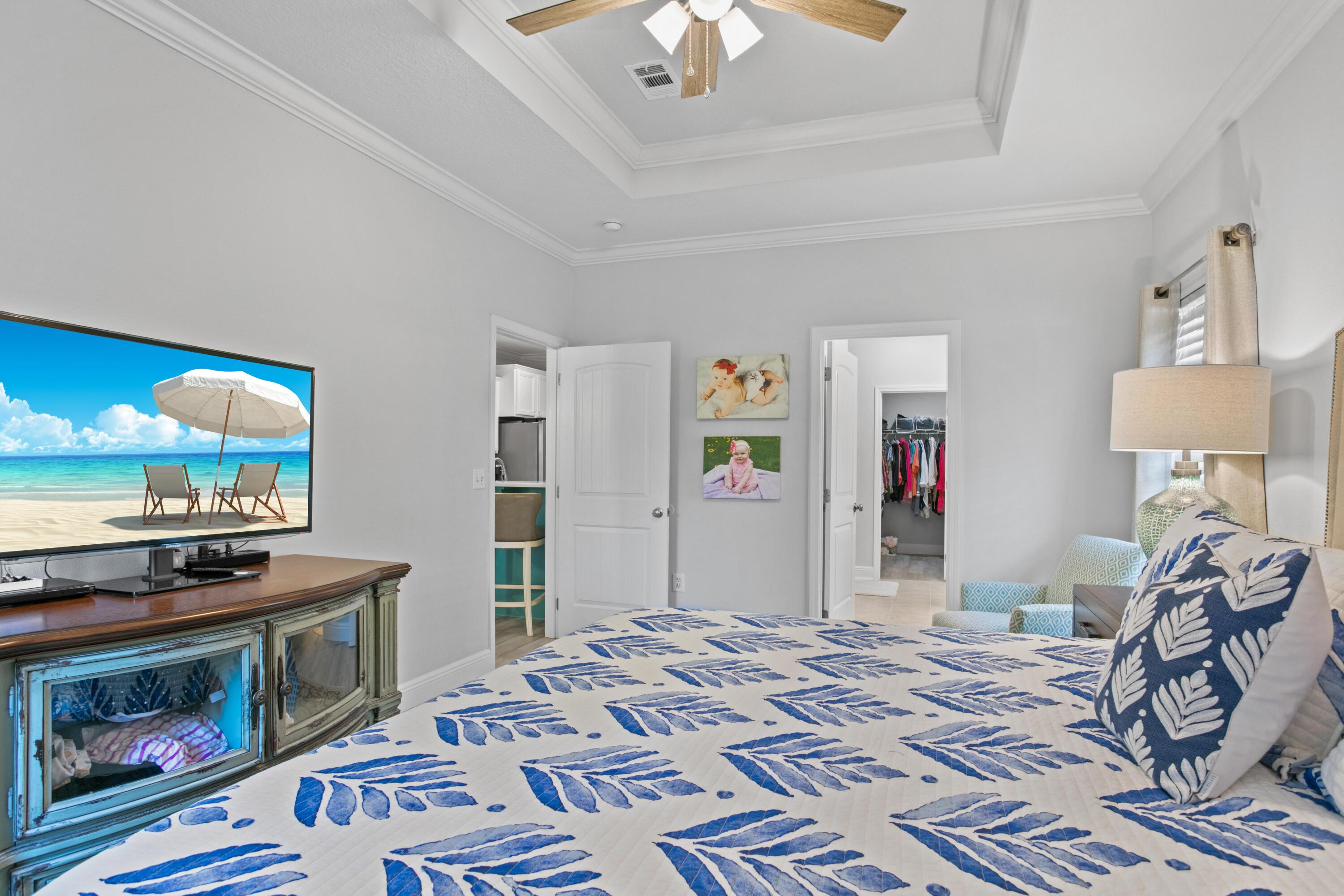 1069 Cocobolo Drive Santa Rosa Beach, FL 32459 - Photo 28 of 46 a bedroom with a bed and a chandelier