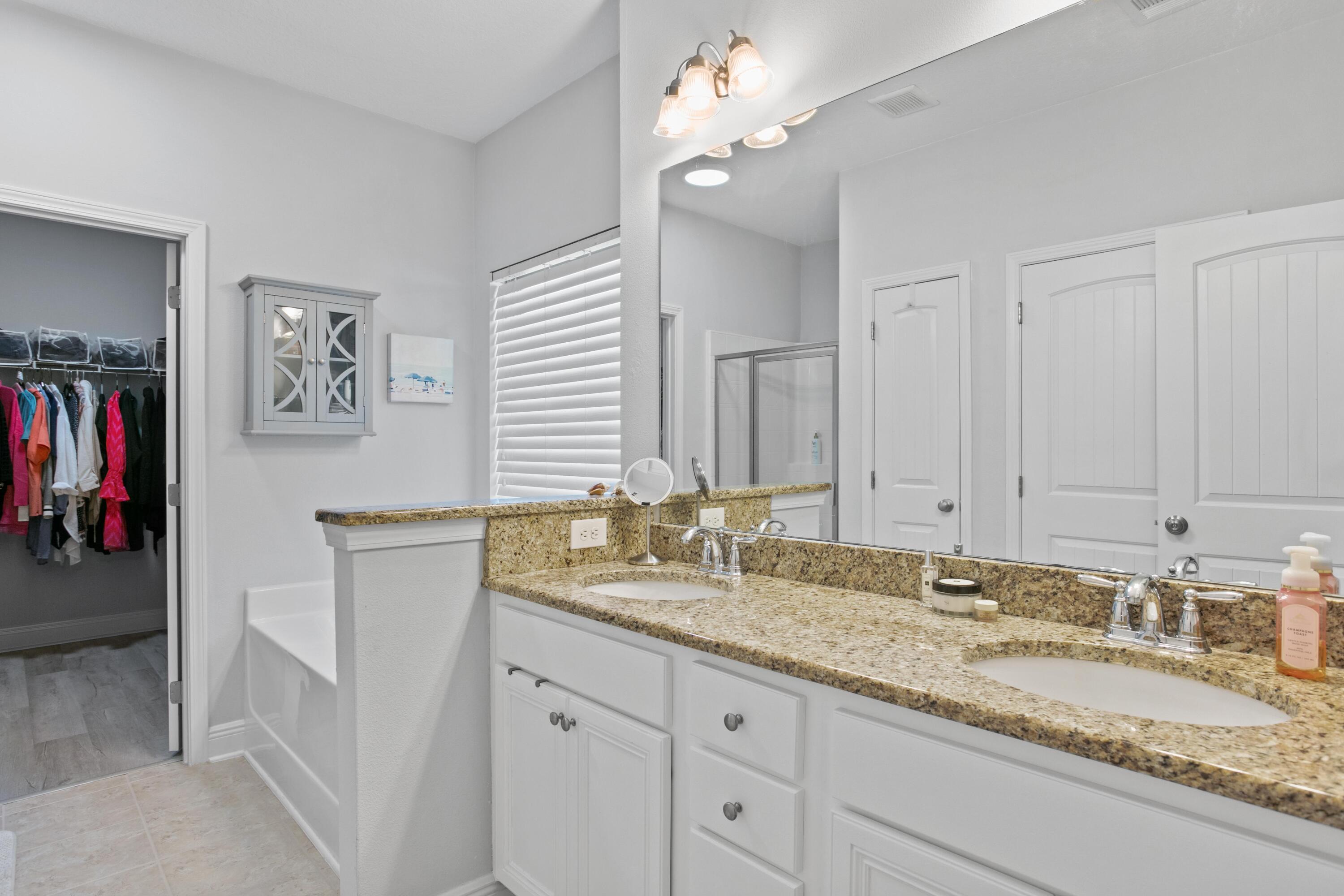 1069 Cocobolo Drive Santa Rosa Beach, FL 32459 - Photo 29 of 46 a bathroom with a granite countertop double vanity sink and a mirror