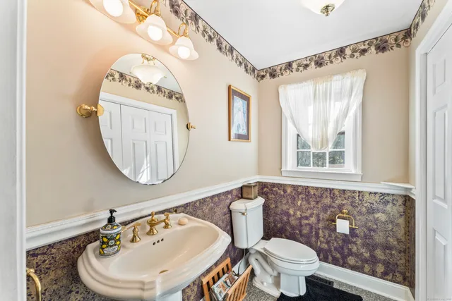 a bathroom with a toilet a sink and a mirror