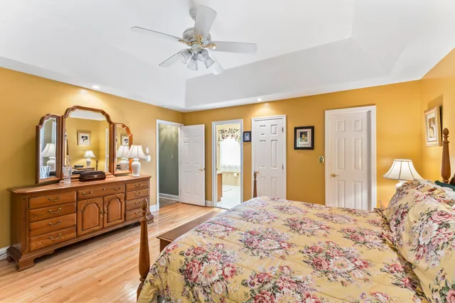 a bedroom with a bed and a large mirror on the dresser