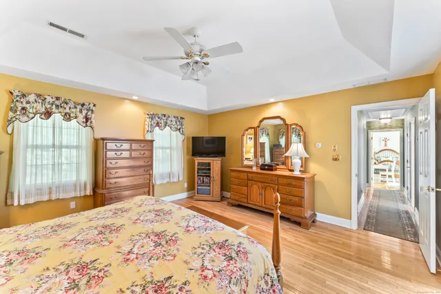 a bedroom with a bed and dresser with mirror