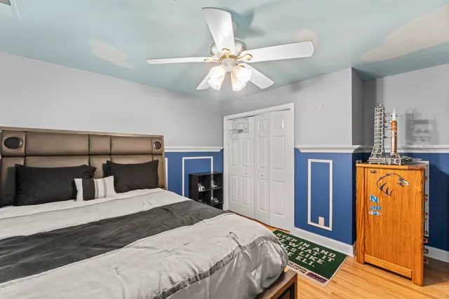a bedroom with a bed and wooden floor