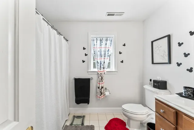 a bathroom with a toilet a sink and a mirror