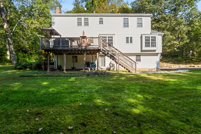a view of a house with a big yard and large trees