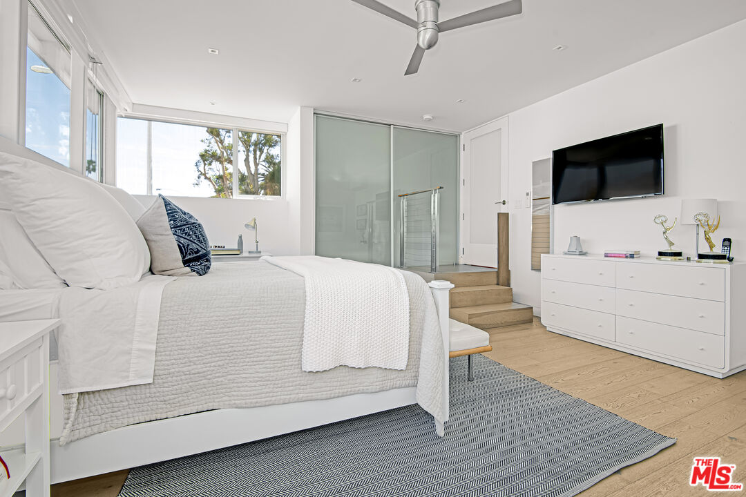 23536 Malibu Colony Road Malibu, CA 90265 - Photo 33 of 44 a bedroom with a large bed a flat tv screen and a dresser