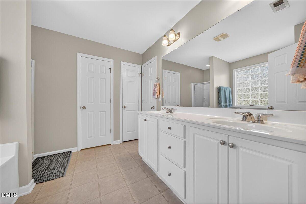 517 Lemon Pepper Place Wendell, NC 27591 - Photo 14 of 19 a spacious bathroom with a double vanity sink and mirror