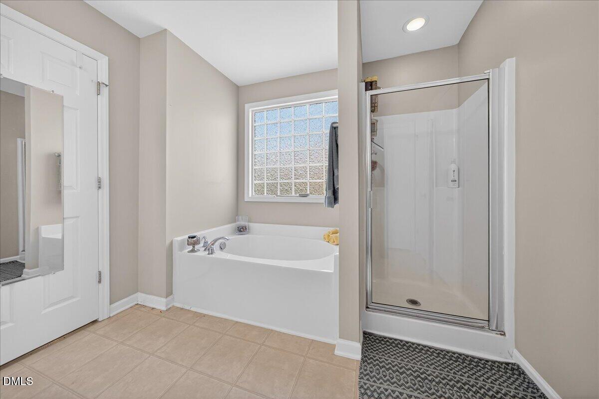 517 Lemon Pepper Place Wendell, NC 27591 - Photo 15 of 19 a bathroom with a bathtub a shower and a sink
