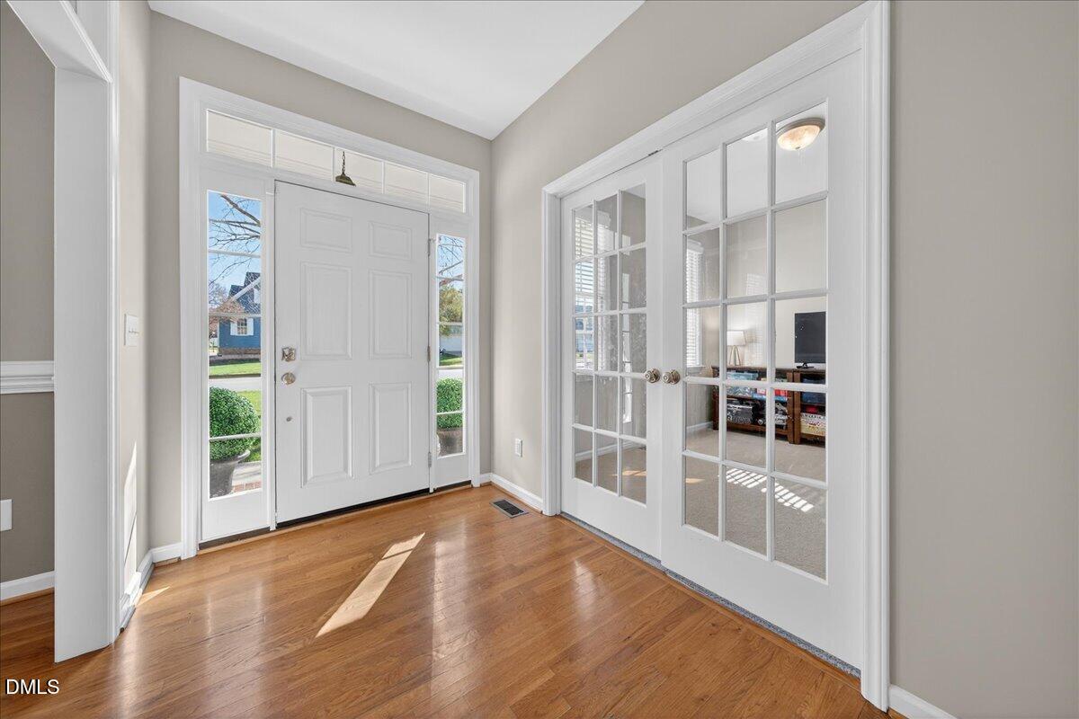 517 Lemon Pepper Place Wendell, NC 27591 - Photo 3 of 19 an empty room with wooden floor and windows
